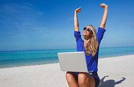 Lady using a laptop on the beach